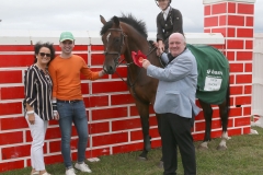 Lee Carey, Crossmolina winner of Puissance at Claremorris 100th Agricultural Show 2018 is presented with rosette by Luke Gibbons, BAM Buildings sponsor included are Francesca and Luke Gibbons, Jnr. Photo: © Michael Donnelly