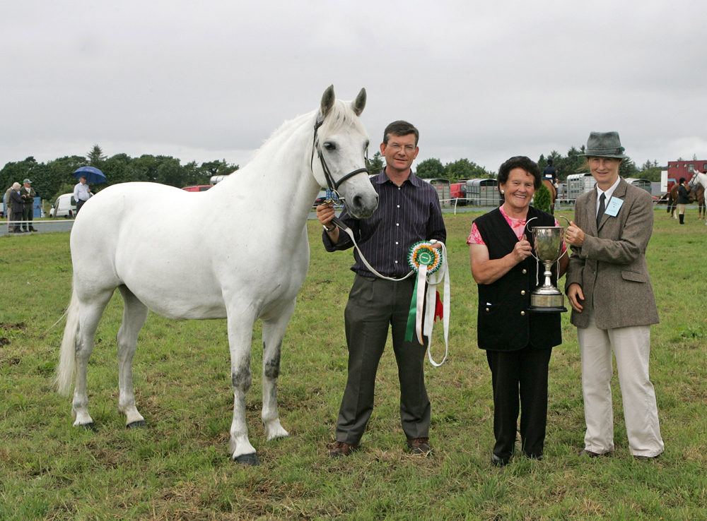 Breda Horan, Castlegar, Galway is presented with the cup for Champion Connemara by Sarah Jacob (judge), at the 88th Claremorris Agricultural Show, Roger Brady shows the champion Pony. Photo: © Michael Donnelly